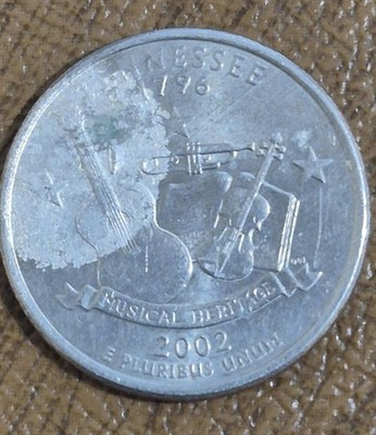 2002 Mississippi quarter lamination error showing a peeling or lifted clad layer revealing copper beneath